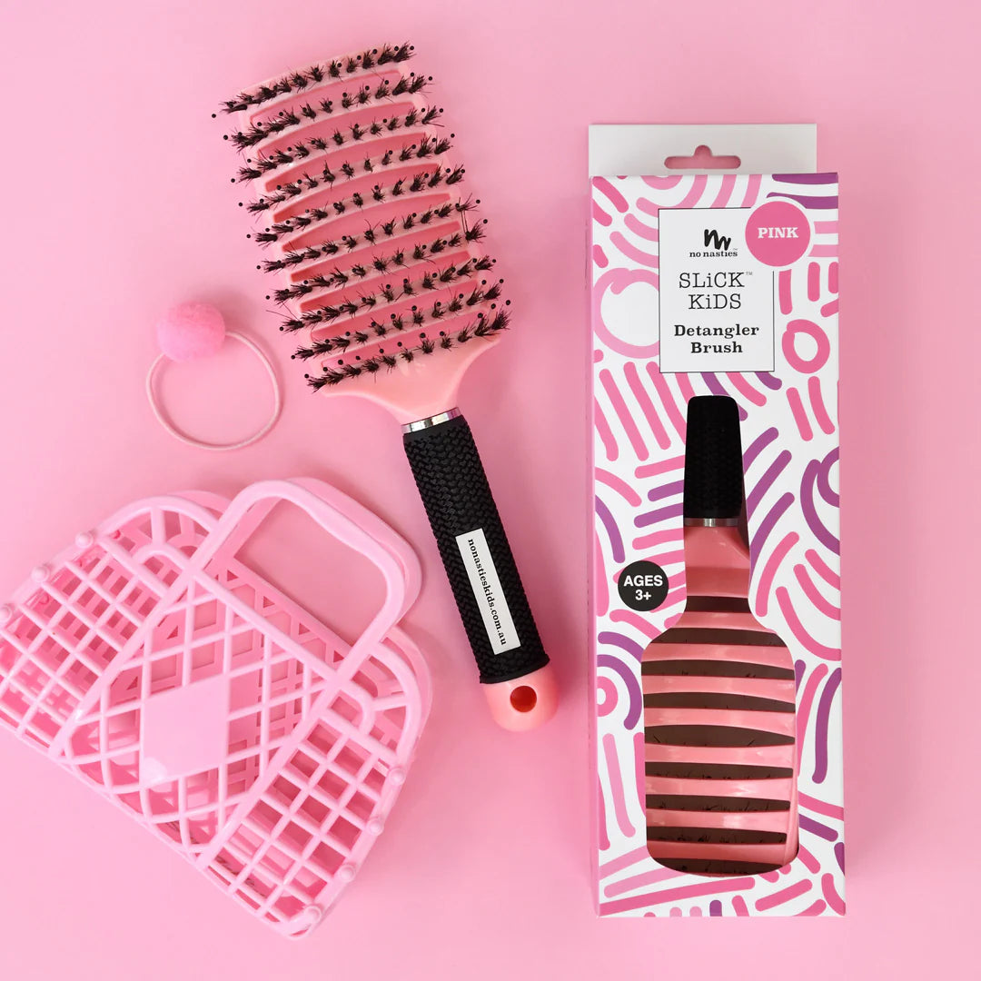 Pink detangler brush with packaging on a pink background