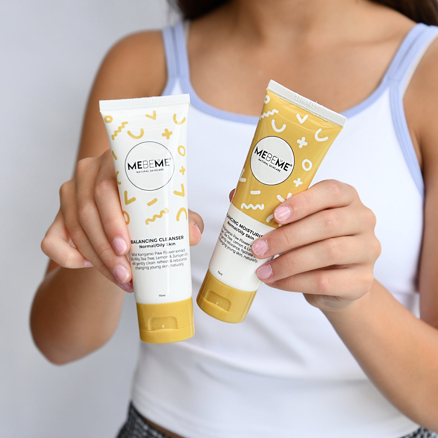 Person holding two MEBEME skincare products against a plain background