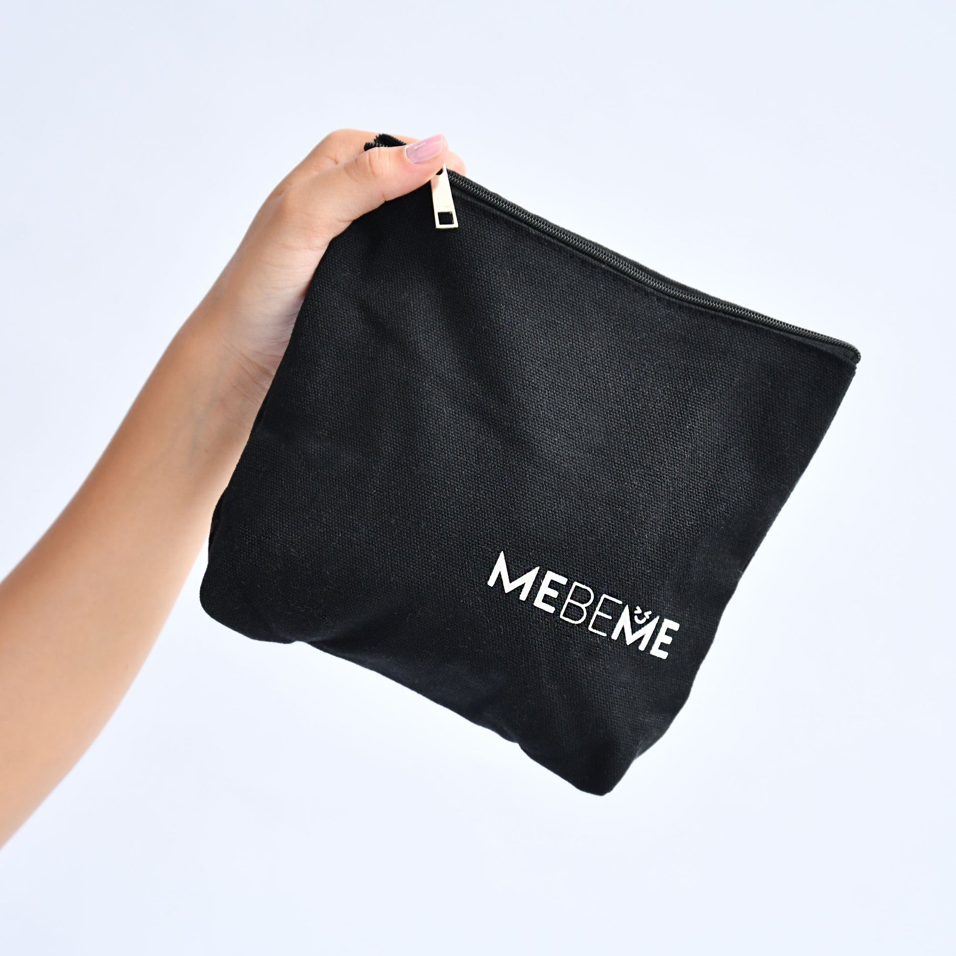 Black pouch with 'MEBEME' branding held by a hand against a light gray background