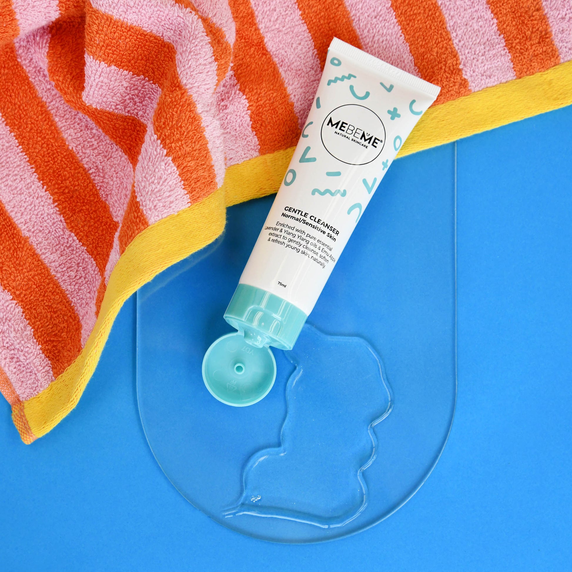 MEBEME Gentle Cleanser tube with a sample on a blue surface with a striped towel.