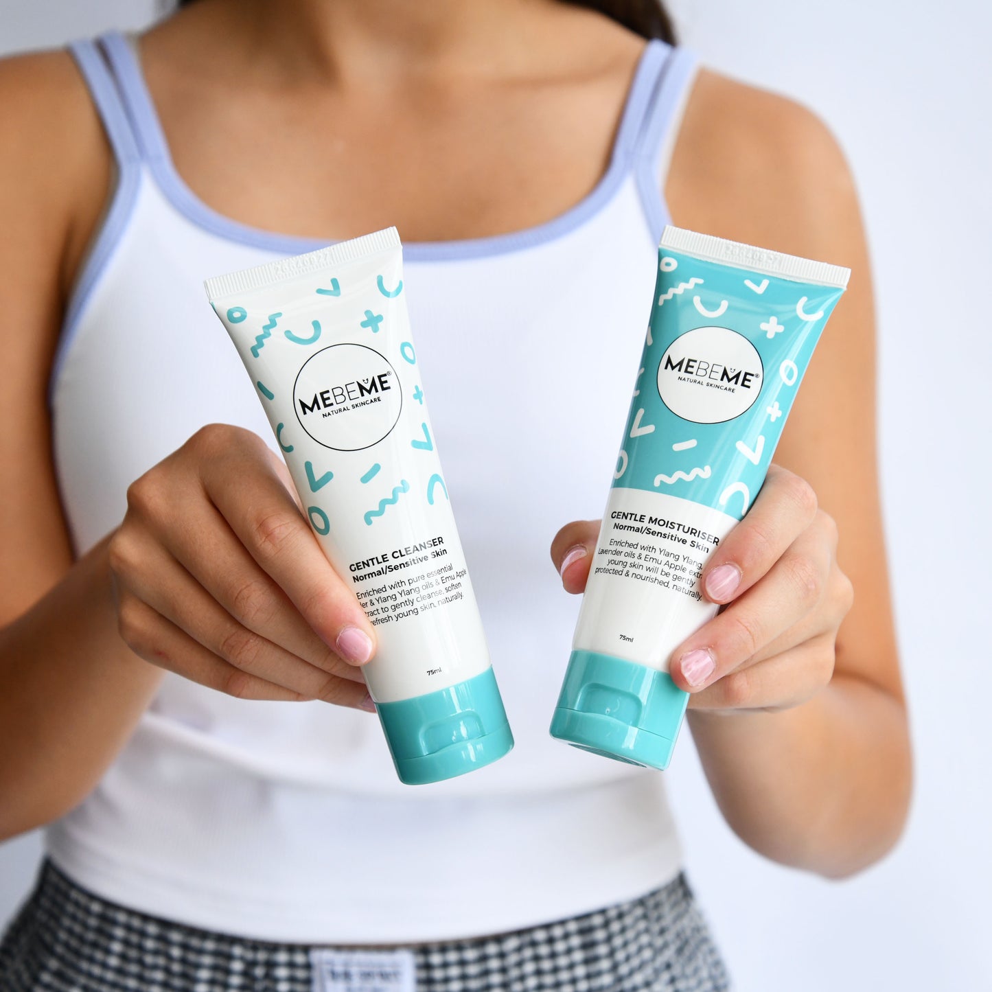 Person holding two MEBEME skincare products against a white background