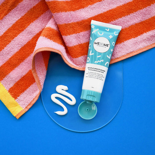 MEBEME tube of gentle moisturiser on a blue surface with a striped towel in the background