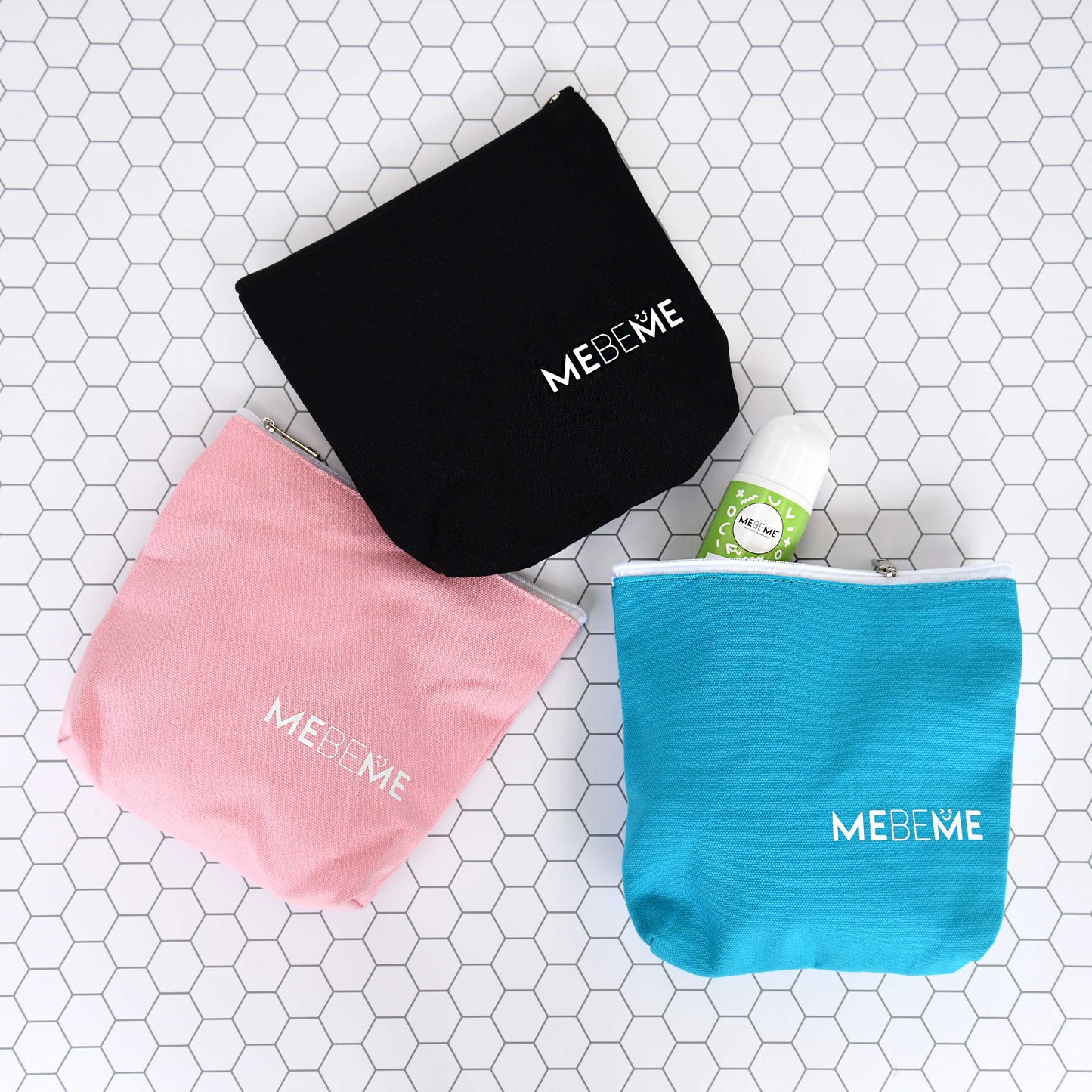 Three MEBEME bags in black, pink, and turquoise on a tiled surface