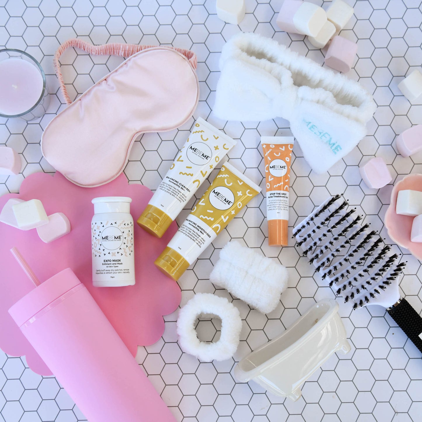 Collection of skincare products on a hexagonal tiled surface