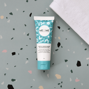 blue and white tube of gentle moisturiser for normal, sensitive and dry skin, with a blue lid. On a green speckled background with a white towel.