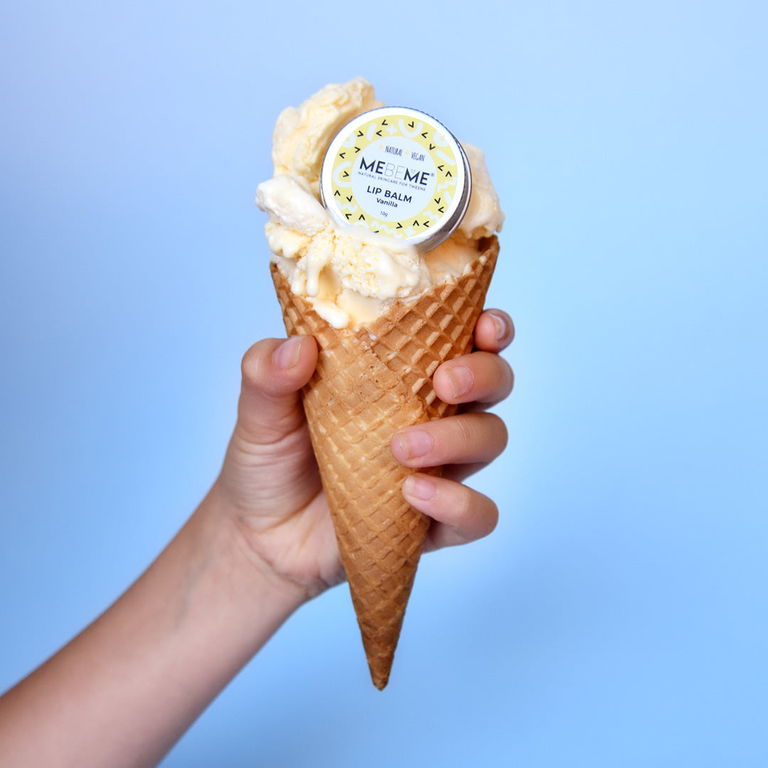 A hand holding a cone with ice cream, which is used to represent a lip balm container with a label that reads 'MEBEME'.